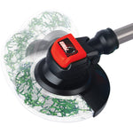 Close-up of the trimmer head on a red and black toy string trimmer showing decorative green faux grass inside clear guard