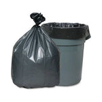 Dark gray tied trash bag placed next to a gray plastic trash can lined with a black bag