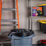 Garage scene with a trash can lined with a black Hefty bag and a Hefty box on a metal shelf beside storage bins