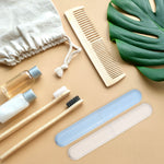 Styled flatlay with speckled blue and beige toothbrush travel cases, bamboo toothbrushes and toiletry items