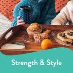 Wooden tray with clear Chinet plates holding muffins, waffles and an orange, styled with promotional ‘Strength & Style’ banner