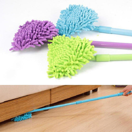 Close arrangement of three triangular microfiber mop heads and handles in blue, purple, and green with a person using a long handle to reach under furniture.