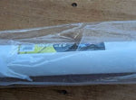 Wrapped white PVC tube with a partially visible product label inside clear plastic on a wooden surface