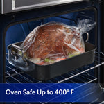 Roasting pan with turkey in a clear oven bag placed on an oven rack, bag tied at the top