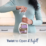 Person twisting open a Bona Pet System refill bottle at a kitchen counter demonstrating twist-to-open refill action.