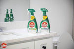 Two Comet Ultra Bathroom Spray bottles placed on a bathroom countertop with a mirror and toilet visible in the background