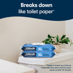 Two Cottonelle XL flushable wipes packs stacked on a closed toilet tank under text stating 'Breaks down like toilet paper'.