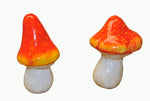 Two orange-red spotted miniature mushroom ornaments shown on a plain white background.