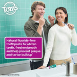 Two people smiling in a bathroom scene with a tube of Tom’s of Maine toothpaste on the counter and a purple product information box.