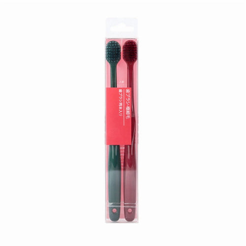 Two slim manual toothbrushes in a clear retail blister pack with a red label, one green and one red handle.