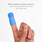 Close-up of a blue silicone finger toothbrush worn on an adult finger with text noting platinum-grade silicone above.