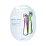 Blister pack packaging showing an Ubbi bristled toddler toothbrush 2-pack with one purple and one green toothbrush visible against pale blue card.