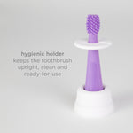 Purple silicone finger brush standing upright in a white hygienic holder with text about cleanliness