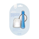 Ubbi silicone training toothbrush set in retail blister pack showing a blue toothbrush and translucent case on a light-blue hanging card.