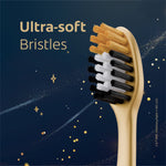 Close-up of toothbrush head highlighting ultra-soft bristles in gold, white, and black on dark background
