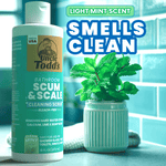 Styled lifestyle shot of Uncle Todd's Scum & Scale bottle beside a mint plant with text highlighting fresh scent