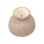 Underside view of a brown ceramic planter showing drainage hole and rounded base details.