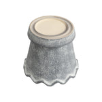 Underside view of a gray scalloped ceramic planter showing the base and textured exterior
