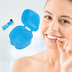Lifestyle-style image of a blue retainer case and small cleaning brush beside a smiling woman holding a clear dental aligner