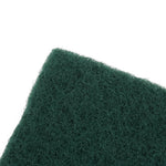 Angled close-up of the fibrous surface and edge of a dark green scouring pad