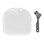 Top-down view of a closed clear plastic retainer case next to a small black multi-bristle cleaning brush