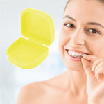 Open yellow retainer case shown beside a smiling person holding a clear dental aligner, lifestyle product image.