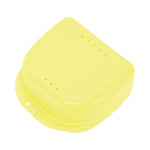 Yellow plastic retainer or braces storage case photographed on a white background, top view with vent holes.