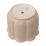 Tan scalloped ceramic planter shown upside down highlighting base and a small rubber plug in drainage hole.