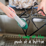 Person using a Scotch-Brite dishwand to scrub a greasy stove grate over a sink, demonstrating soap-at-the-push-button use