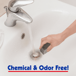 Hand holding a gray pumice scouring stick over a sink drain with running water, advert text below