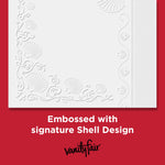 Close-up of a white embossed napkin corner showing shell and scroll border on a red background