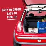 Open car trunk containing a Vanity Fair Everyday napkin pack and a blue Walmart shopping bag with pickup text