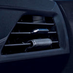 Close-up photograph of a black car air vent with a cylindrical vent wrap clipped onto a horizontal vent blade
