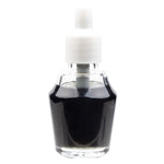 Close studio shot of a small glass fragrance oil bottle with white screw cap and dark liquid inside