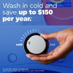 Hand turning a washer temperature dial from hot toward cold with overlay text about washing in cold to save up to $150 per year.