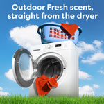 Washer with laundry basket on top in a grassy outdoor-themed scene and text 'Outdoor Fresh scent, straight from the dryer'