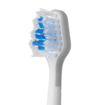 Close-up of a white electric toothbrush head showing layered blue and white bristles and textured neck.