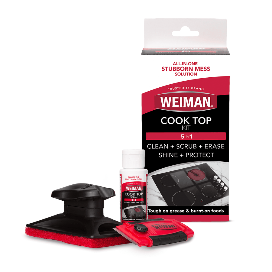 Product shot of Weiman Cook Top kit showing bottle of cleaner, red scraper, black scrubbing tool and retail box on white background