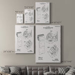Room mockup showing five sizes of gallery-wrapped canvases with the toilet paper holder patent illustration arranged above a sofa.