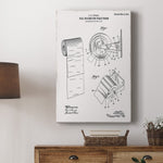 Wall scene with a vertical gallery-wrapped canvas featuring a vintage patent drawing of a toilet paper roll and dispenser hung above a console table.