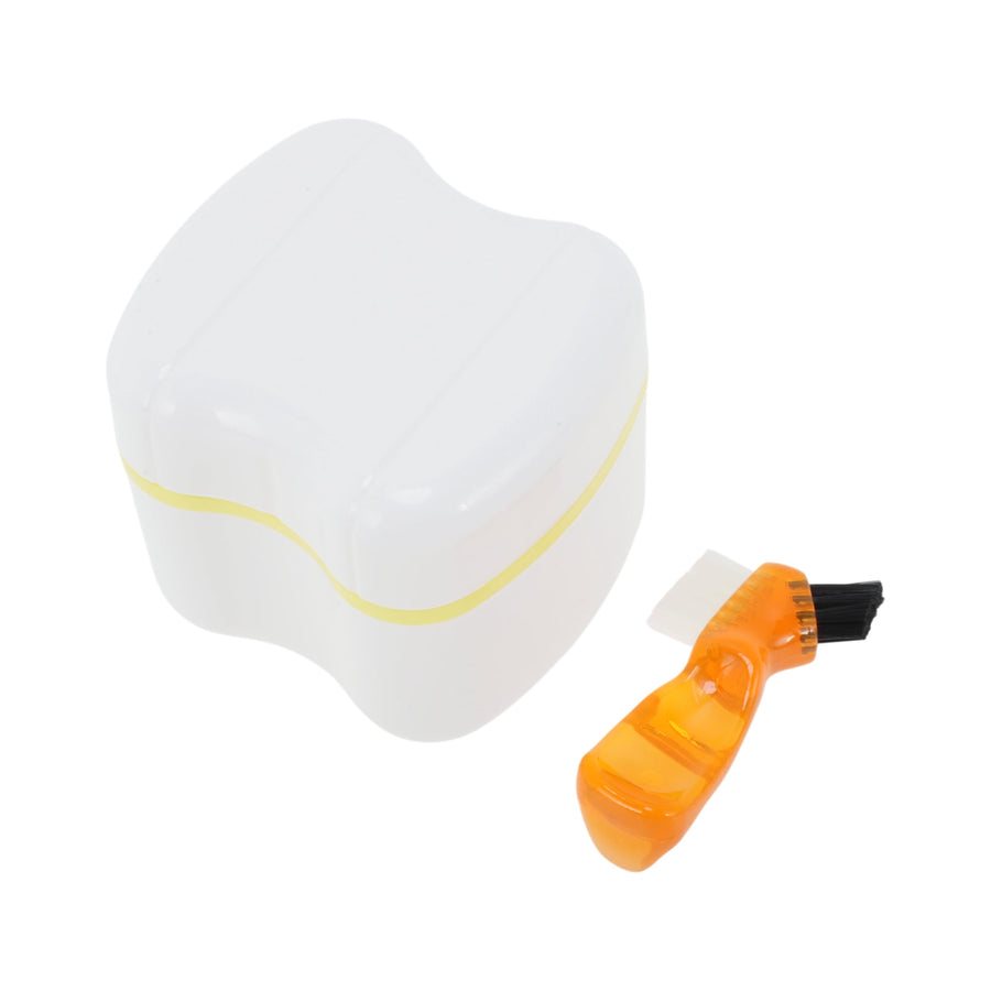 White plastic denture storage case with a yellow trim shown next to a small orange denture-cleaning brush