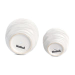 Undersides of two white wavy ceramic pots showing drainage holes and the brand name 'Nattol' printed on the bases.