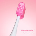 White brush neck with a translucent pink Wicked-themed travel cap placed over the head