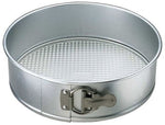 Silver aluminum springform pan with latch fastener and textured removable base shown at slight angle
