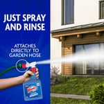 Hand holding Windex Outdoor spray bottle attached to a garden hose spraying a house exterior