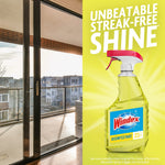 Windex spray bottle on a yellow background beside a bright balcony door with text claiming unbeatable streak-free shine.