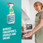 Windex with Vinegar spray bottle next to a person wiping a stovetop, kitchen setting