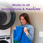 Smiling woman holding and smelling a blue garment next to a front-loading washer with text about working in all temperatures and machines.