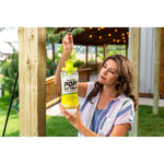 Woman hanging a filled OUTDOOR POP! Fly Trap from a hook on a wooden post on a covered patio