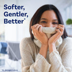 Smiling woman cuddling a knit sweater with headline text reading ‘Softer, Gentler, Better’ against a soft-focused home interior